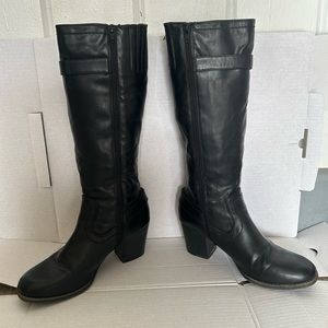 Almost knee high, heeled black faux leather zip up boots.